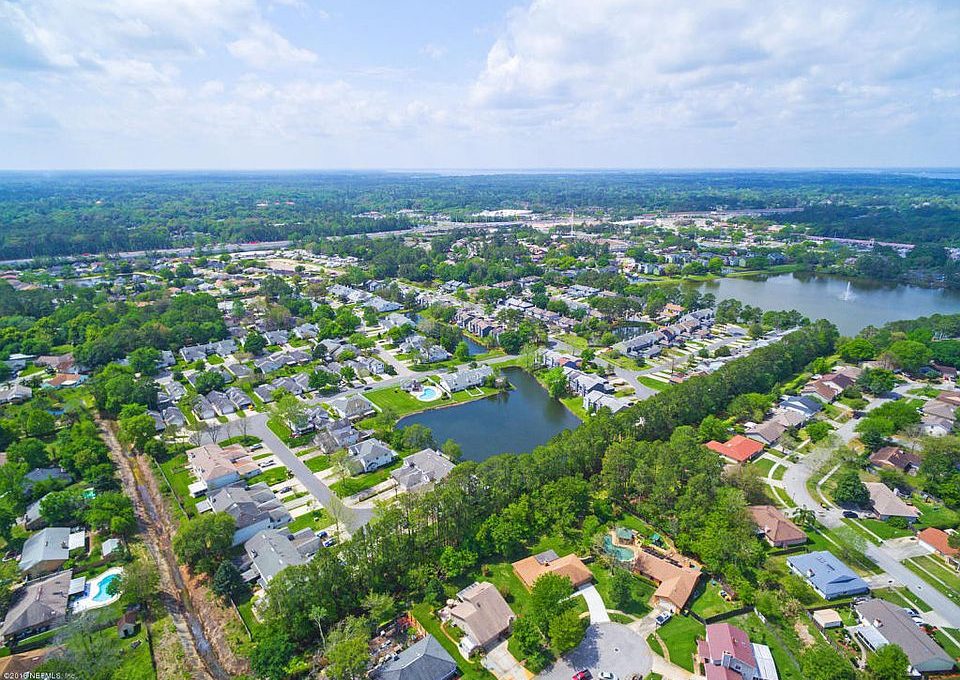 an aerial view of a neighborhood with lots of trees and water at The Vista Bay