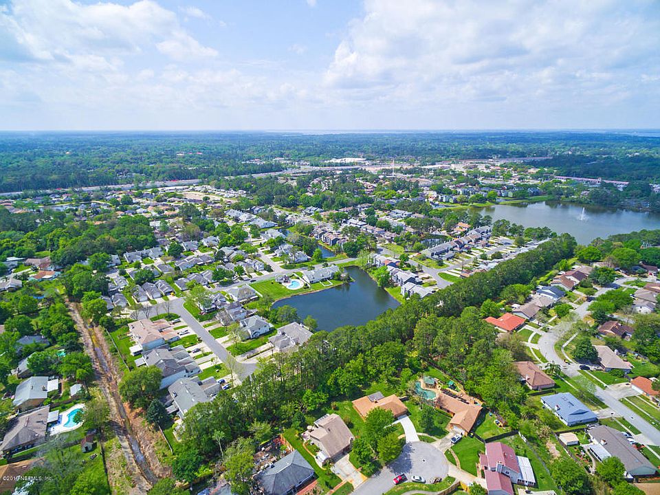 an aerial view of a neighborhood with lots of trees and water at The Vista Bay