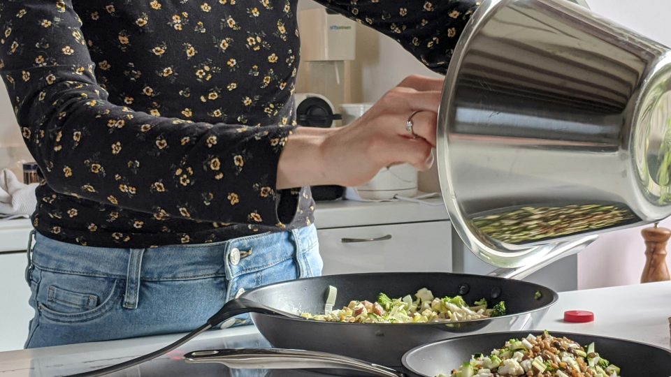 a woman is cooking in a pan with a lid at The Vista Bay