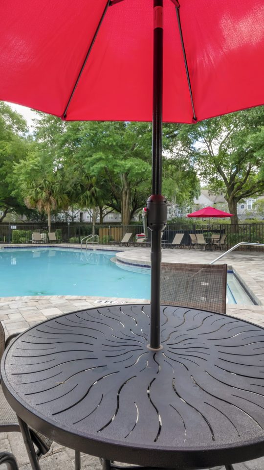 a patio table and chairs with an umbrella over it at The Vista Bay