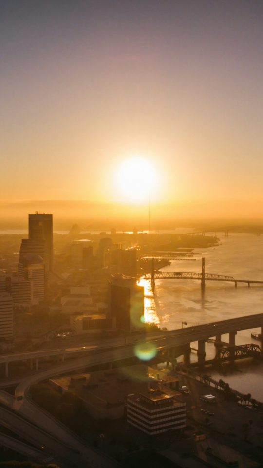 aerial photography of bridge and building beside river during sunset