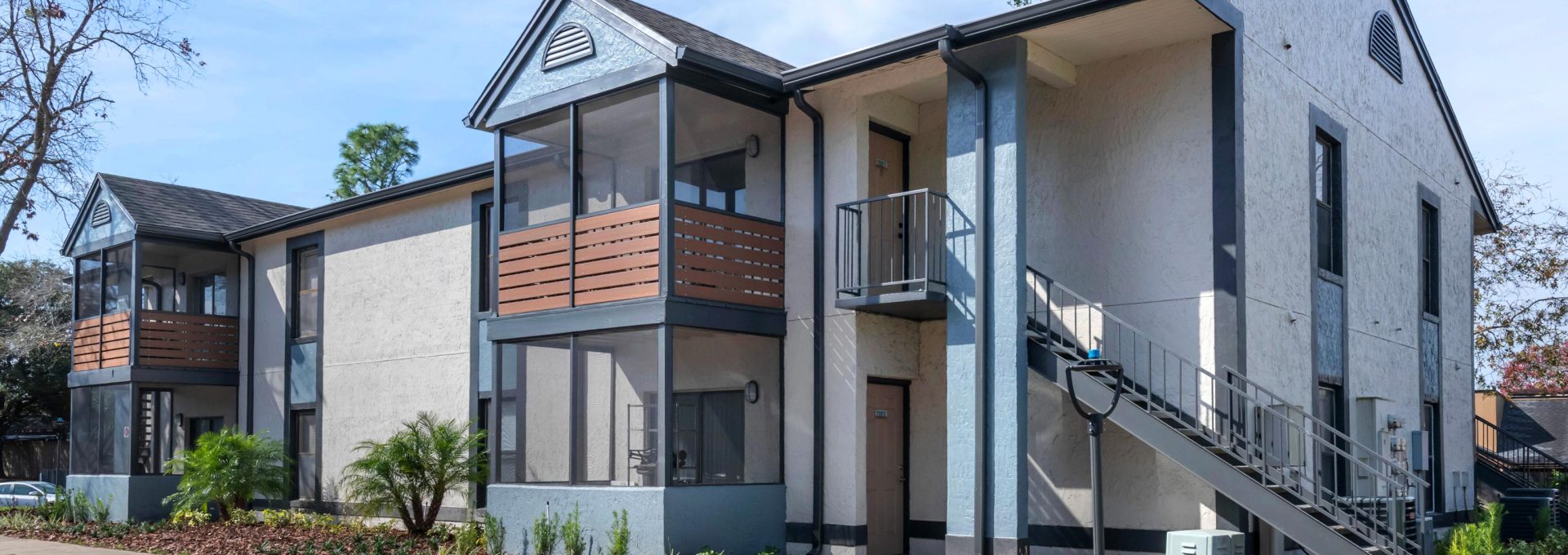 the exterior of an apartment building with stairs and a parking lot at The Vista Bay
