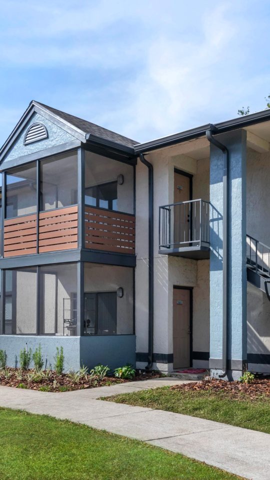 the exterior of an apartment building with stairs and a parking lot at The Vista Bay