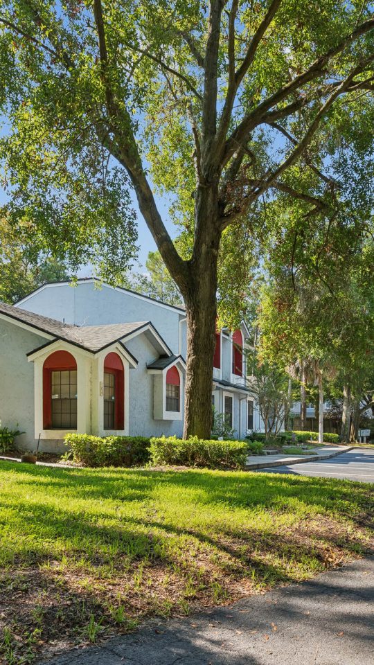 a home in the middle of a neighborhood with trees and grass at The Vista Bay