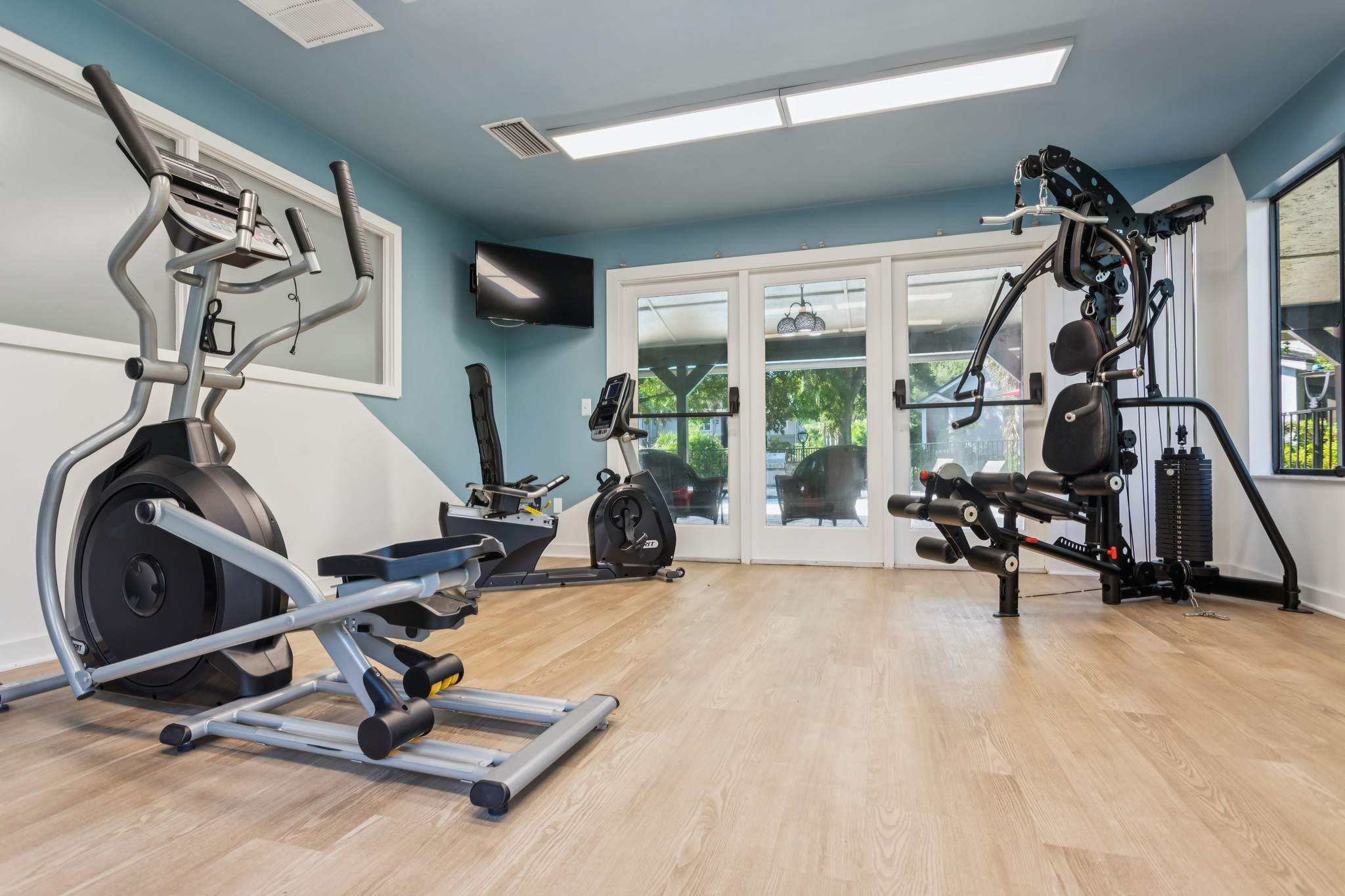 a gym room with exercise equipment and blue walls at The Vista Bay